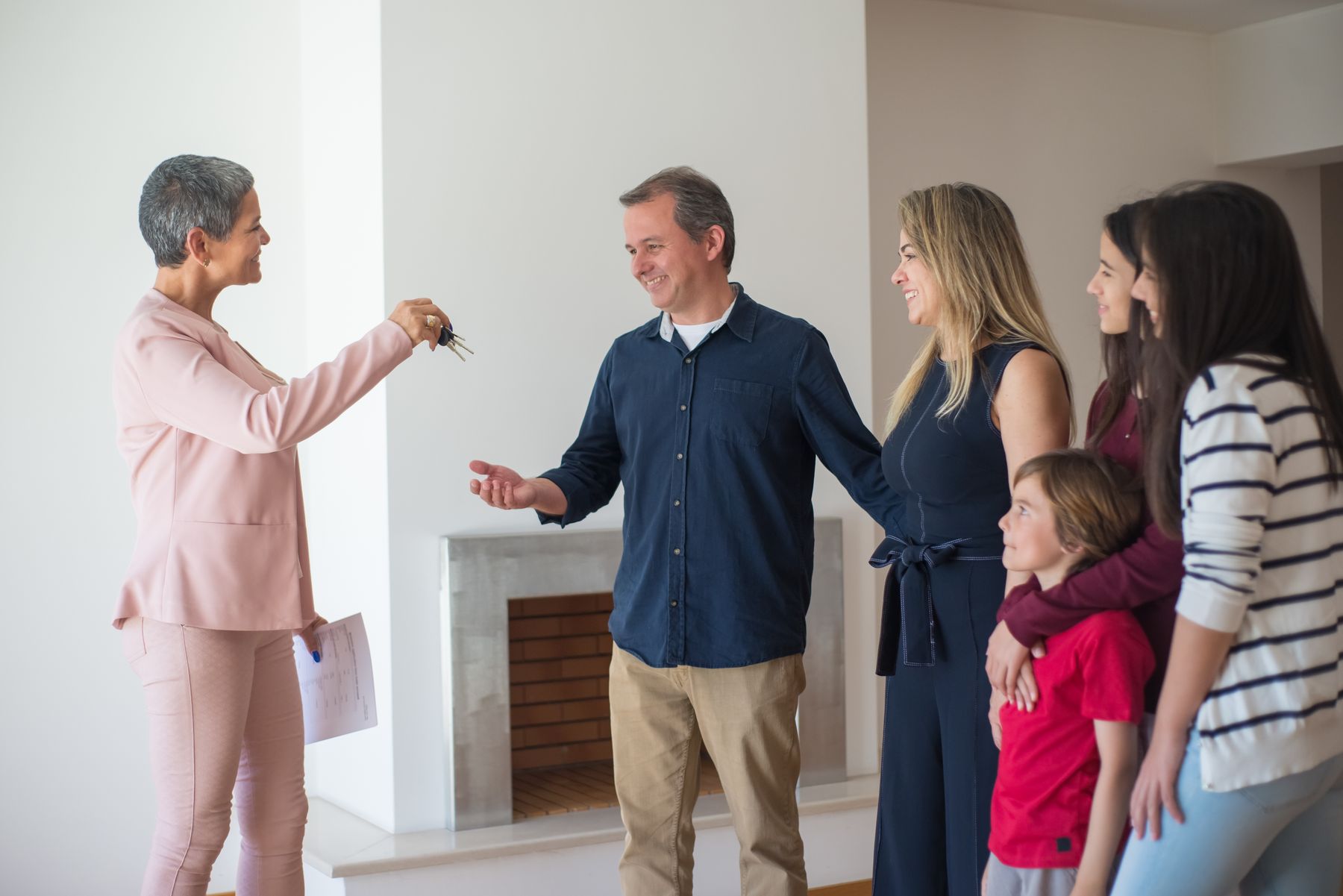 A smiling family receiving the keys to their new home